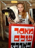 פעילת אנונימוס מחבקת עגל בפעילות שערכו פעילי אנונימוס במשק בצרה