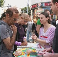 עוברי אורח טועמים אוכל טבעוני וחותמים על עצומות